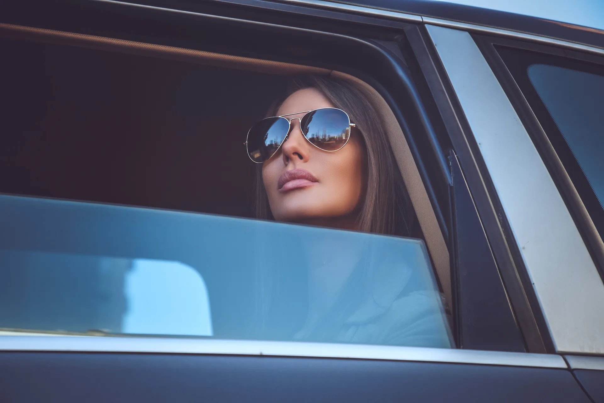 A guest relaxing in the back of a chauffeured Canadian Limos vehicle